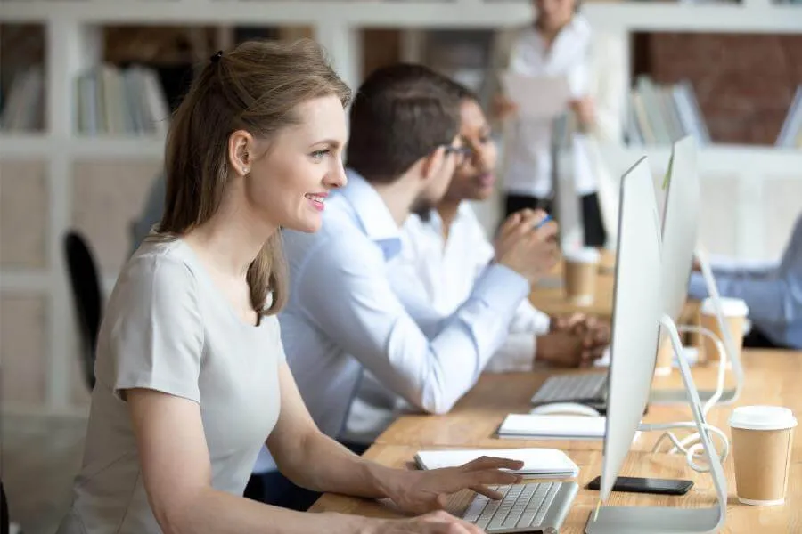 Blije medewerker aan het werk achter computer