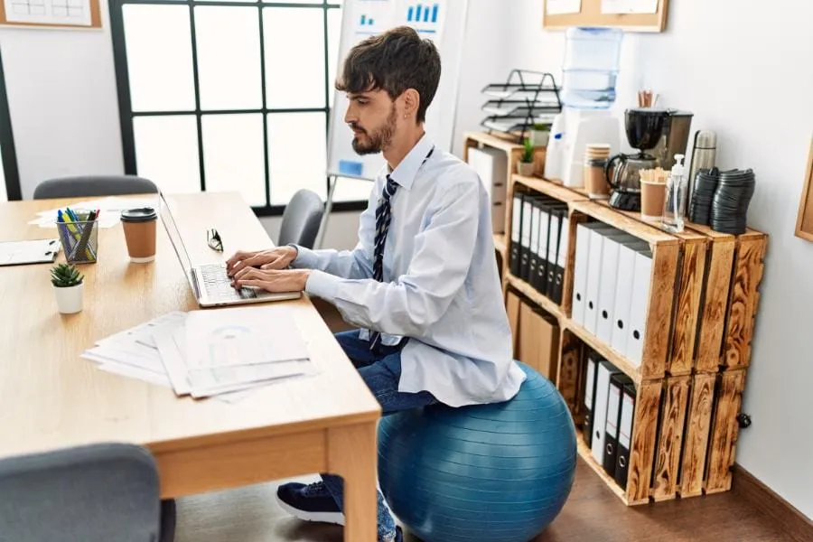 Man op zitbal aan het werk