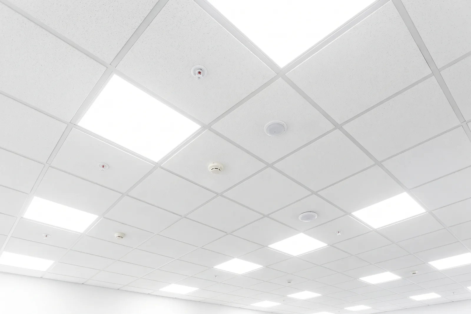 Wit systeemplafond met witte plafondplaten en ingebouwde LED-panelen