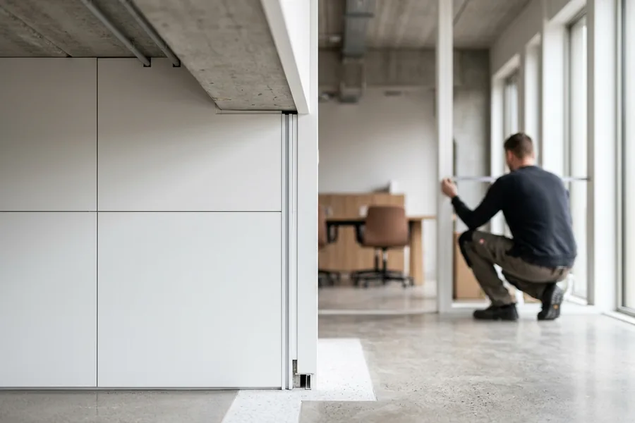 Monteur installeert een wand in een modern kantoor in verbouwing